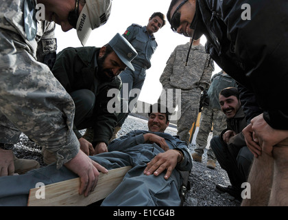 U.S. Soldiers with the 402nd Brigade Support Battalion teach Afghan National Police the proper application of a splint during t Stock Photo