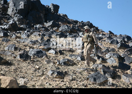 U.S. Marine Corps Lance Cpl. Ryan M. Martin, of Lima Company, 3rd Battalion, 4th Marine Regiment, hikes down a rocky hillside i Stock Photo