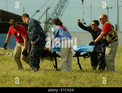 U.S. Navy Interior Communications Electrician 1st Class Frank Pontrelli, second from right, directs a team transporting an inju Stock Photo