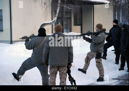 Two U.S. Navy SEALs pull security as another talks to a group during a demonstration for Lithuanian and Latvian special operati Stock Photo