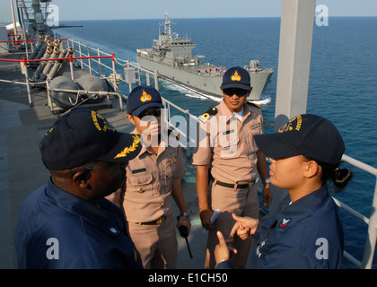 U.S. Navy Cmdr. Antonio Hull, left, executive officer of USS Harpers Ferry (LSD 49), listens to Electronics Technician 2nd Clas Stock Photo