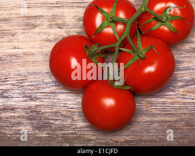 Red tomatoes on rustic wooden background Stock Photo