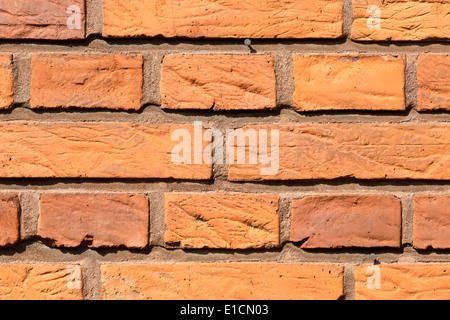 Close-up of weathered red brick wall on a sunny day. Stock Photo