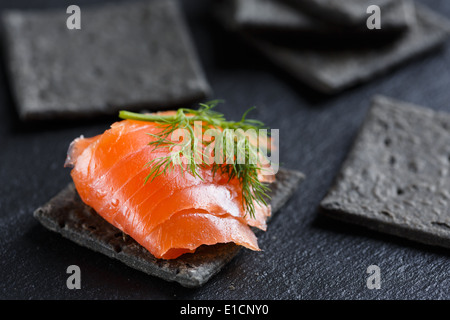 Smoked Salmon on black cracker Stock Photo