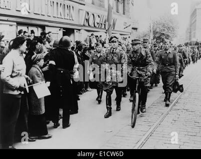 Nazi soldiers march down a commercial street in German-occupied Denmark in 1945. Denmark was one of the last occupied countries Stock Photo