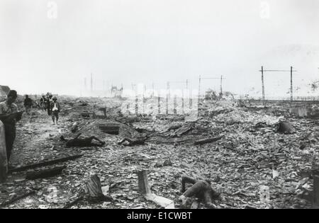 Ruins of Nagasaki, Japan, after atomic bombing of August 9, 1945. Government officials walk amid radioactive debris and burnt Stock Photo