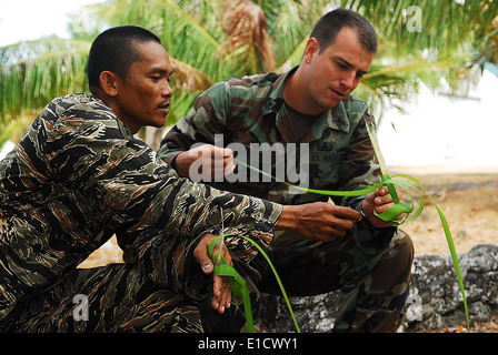 A member of the Philippine Naval Special Warfare Group teaches U.S. Navy Explosive Ordnance Disposal Technician 1st Class Kyle Stock Photo