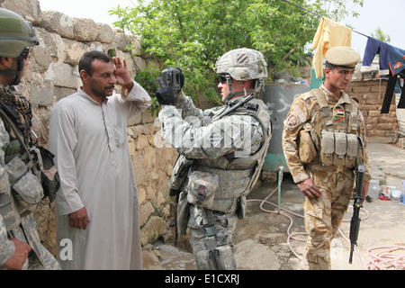 U.S. Army Sgt. David Kratzer photographs an Iraqi man in Badoush, Iraq, April, 3, 2010. Kratzer, who is assigned to Crazy Horse Stock Photo