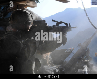 U.S. Army Pfc. Timothy D. Prescott returns fire during an attack on Combat Outpost Bari Alai in the Kunar province of Afghanist Stock Photo
