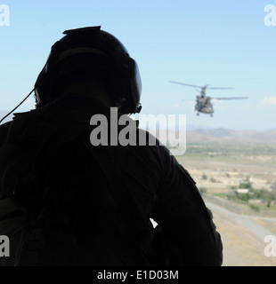 U.S. Army Staff Sgt. Nicholas Sheffield keeps a watchful eye from the back of a CH-47 Chinook helicopter while transporting com Stock Photo