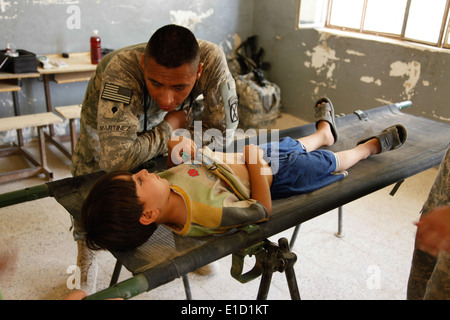 A U.S. Soldier assigned to 2nd Battalion, 14th Infantry Regiment, 2nd Brigade Combat Team, 10th Mountain Division speaks with a Stock Photo