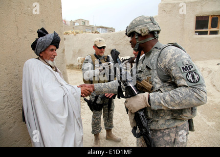 U.S. Army Staff Sgt. Michael Baldwin shakes hands with an elder in the village of Mirsaleh in the Logar province of Afghanistan Stock Photo
