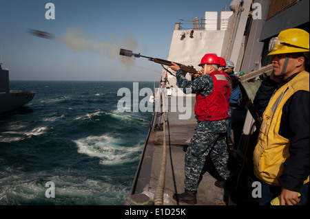 U.S. Navy Gunner's Mate 2nd Class Steven Moore, stationed aboard the USS New Orleans (LPD 18), fires a shot line over to the US Stock Photo