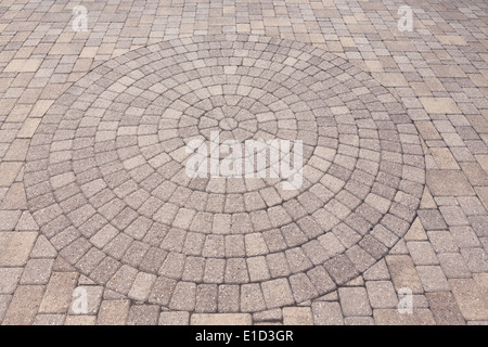 Architectural background of an ornamental pattern in outdoor patio paving with bricks arranged in a circular pattern of concentr Stock Photo