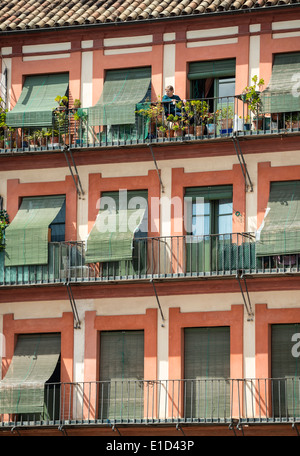 A woman surveys the square from her balcony in the Plaza de la Corredera, Cordoba, Spain. Stock Photo