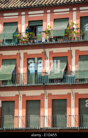 A woman surveys the square from her balcony in the Plaza de la Corredera, Cordoba, Spain. Stock Photo