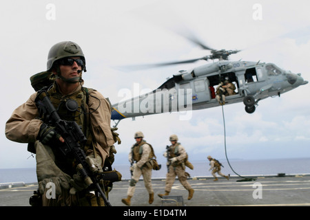 A U.S. Marine with Force Reconnaissance Platoon, 31st Marine Expeditionary Unit (31st MEU) provides security as Marines from Ch Stock Photo