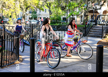 Teenage girls riding hired bicycles as they tour around Savannah GA Stock Photo