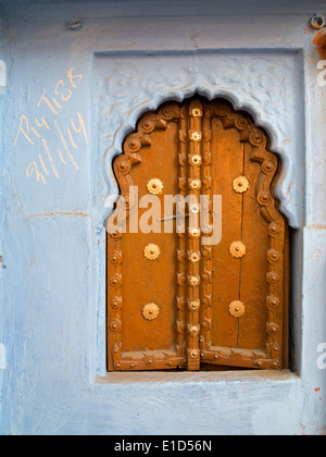 India, Rajasthan, Jodhpur, Mughal arch shaped shuttered window in blue painted wall Stock Photo