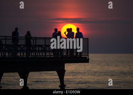 Aberystwyth Wales UK, Saturday 31 May 2014  A group of men drinking and relaxing on the end of Aberystwyth's Victorian pier as the sun sets over Cardigan Bay on the west wales coast   photo Credit: keith morris/Alamy Live News Stock Photo