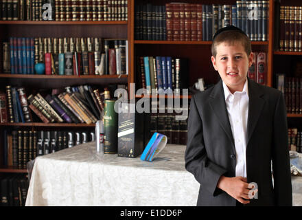 (140601) -- JERUSALEM, June 1, 2014 (Xinhua) -- Tzviel Noyman stands in front of book shelves at his home in Beit Shemesh, about 20 km from Jerusalem, on May 30, 2014. Tzviel Noyman is an Israeli Ultra-Orthodox boy in a family with six children, three boys and three girls. He is ten years old this year and a grade three pupil of Torat Moshe elementary school, which is only opened to Jewish children. Tzviel has eight classes each day, including Hebrew, English, mathematics and Jewish religion, which has four classes each day including Talmud, Mishnah and Gemara. Tzviel likes the religion class Stock Photo