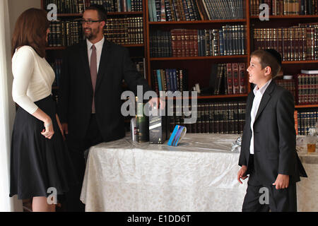 (140601) -- JERUSALEM, June 1, 2014 (Xinhua) -- Tzviel Noyman is seen with his parents at their home in Beit Shemesh, about 20 km from Jerusalem, on May 30, 2014. Tzviel Noyman is an Israeli Ultra-Orthodox boy in a family with six children, three boys and three girls. He is ten years old this year and a grade three pupil of Torat Moshe elementary school, which is only opened to Jewish children. Tzviel has eight classes each day, including Hebrew, English, mathematics and Jewish religion, which has four classes each day including Talmud, Mishnah and Gemara. Tzviel likes the religion class best Stock Photo