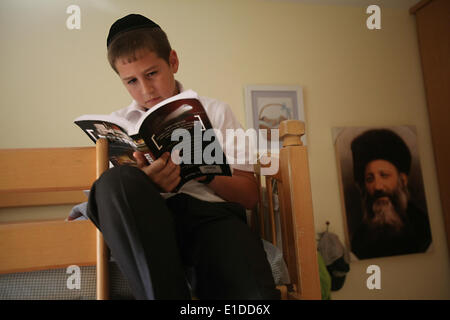 (140601) -- JERUSALEM, June 1, 2014 (Xinhua) -- Tzviel Noyman reads a book at his home in Beit Shemesh, about 20 km from Jerusalem, on May 30, 2014. Tzviel Noyman is an Israeli Ultra-Orthodox boy in a family with six children, three boys and three girls. He is ten years old this year and a grade three pupil of Torat Moshe elementary school, which is only opened to Jewish children. Tzviel has eight classes each day, including Hebrew, English, mathematics and Jewish religion, which has four classes each day including Talmud, Mishnah and Gemara. Tzviel likes the religion class best because he thi Stock Photo