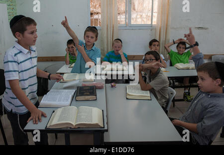 (140601) -- JERUSALEM, June 1, 2014 (Xinhua) -- Tzviel Noyman (1st L) asks a question when leading a class of Jewish religion at Torat Moshe elementary school in Beit Shemesh, about 20 km from Jerusalem, on May 29, 2014. Tzviel Noyman is an Israeli Ultra-Orthodox boy in a family with six children, three boys and three girls. He is ten years old this year and a grade three pupil of Torat Moshe elementary school, which is only opened to Jewish children. Tzviel has eight classes each day, including Hebrew, English, mathematics and Jewish religion, which has four classes each day including Talmud, Stock Photo