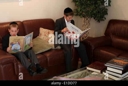 (140601) -- JERUSALEM, June 1, 2014 (Xinhua) -- Tzviel Noyman (R) and his brother Dudik Noyman read books at their home in Beit Shemesh, about 20 km from Jerusalem, on May 30, 2014. Tzviel Noyman is an Israeli Ultra-Orthodox boy in a family with six children, three boys and three girls. He is ten years old this year and a grade three pupil of Torat Moshe elementary school, which is only opened to Jewish children. Tzviel has eight classes each day, including Hebrew, English, mathematics and Jewish religion, which has four classes each day including Talmud, Mishnah and Gemara. Tzviel likes the r Stock Photo