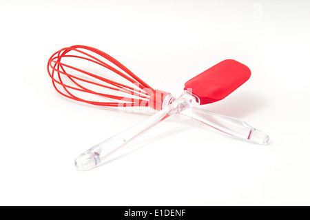 Red egg-beater and creaming spoon on white background Stock Photo