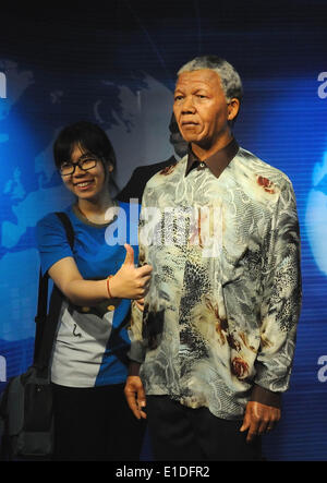 (140601) -- BEIJING, June 1, 2014 (Xinhua) -- A visitor poses for photos with a wax figure of late South African President Nelson Mandela at the Madame Tussauds Wax Museum in Beijing, capital of China, May 31, 2014. (Xinhua) (ry) Stock Photo