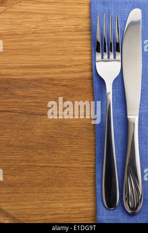 knife and fork at napkin on wooden board Stock Photo