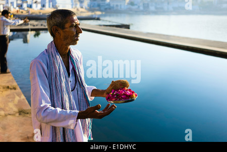 A Hindu man offers prayers at the holy lakeside at dawn on October 24, 2011 at Pushkar, Rajasthan, India. Stock Photo