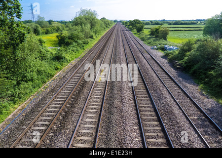 Four parallel railway train tracks leading into the distance Stock Photo