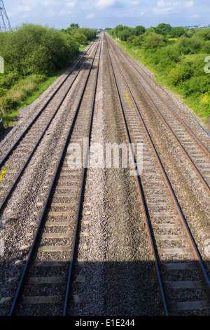 Four parallel railway train tracks leading into the distance Stock Photo