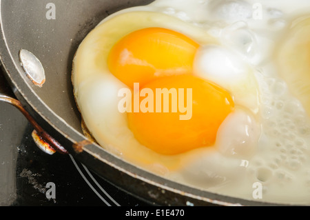 A "double yolker" egg in a frying pan. Stock Photo
