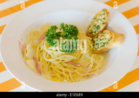 Spaghetti Carbonara with bacon and garlic bread on dish Stock Photo