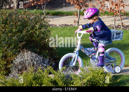 Four 4 year old girl riding her bike Stock Photo