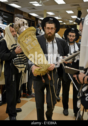 Religious Jewish men carry the Torah back to the holy ark during morning services at the Lubavitch synagogue in NYC Stock Photo