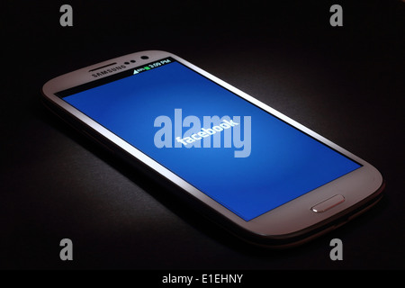 Facebook application on smart phone screen. Facebook is the world’s largest social network Stock Photo