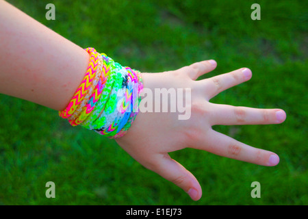 Young girl showing off rainbow loom band bracelets on her wrist Stock Photo