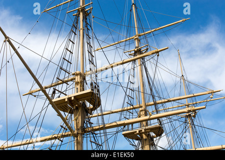 Masts and rigging of a big old sailing ship in front of a blue sky Stock Photo