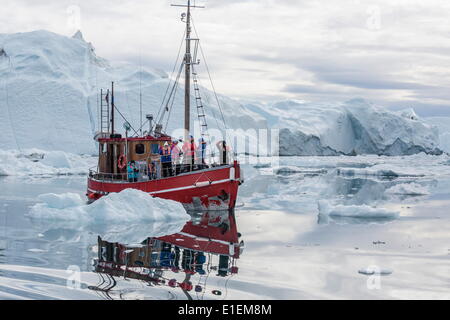 A commercial iceberg tour amongst huge icebergs calved from the Ilulissat Glacier, UNESCO Site, Ilulissat, Greenland Stock Photo