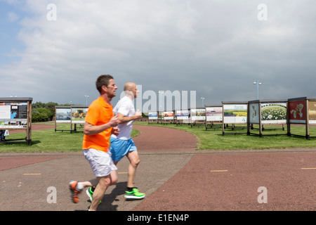 Runners Passing the 2020Vison Outdoor Exhibition in the Coastal Town of Morecambe Lancaster UK Stock Photo