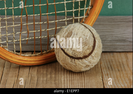 old tennis ball and racket on a wooden floor Stock Photo