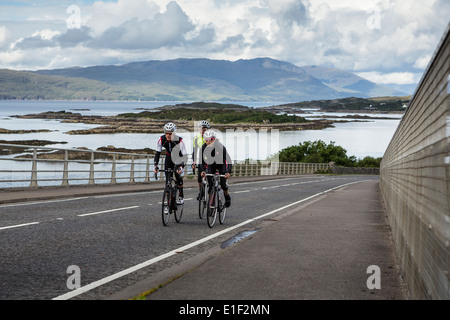 Three cyclists ride up a steep path on the Isle of Skye Stock Photo