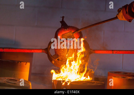 Pouring molten aluminum to make a sculpture. Stock Photo