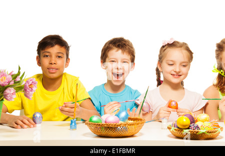 Kids with laughing boy colouring Eastern eggs Stock Photo