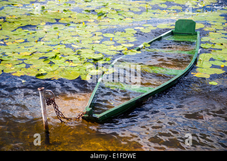 Sunk boat full of water at the lake Stock Photo