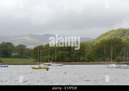 Yachts moored near Ambleside on Lake Windermere in the English Lake District on a breezy and grey cloudy morning in late Spring. Stock Photo